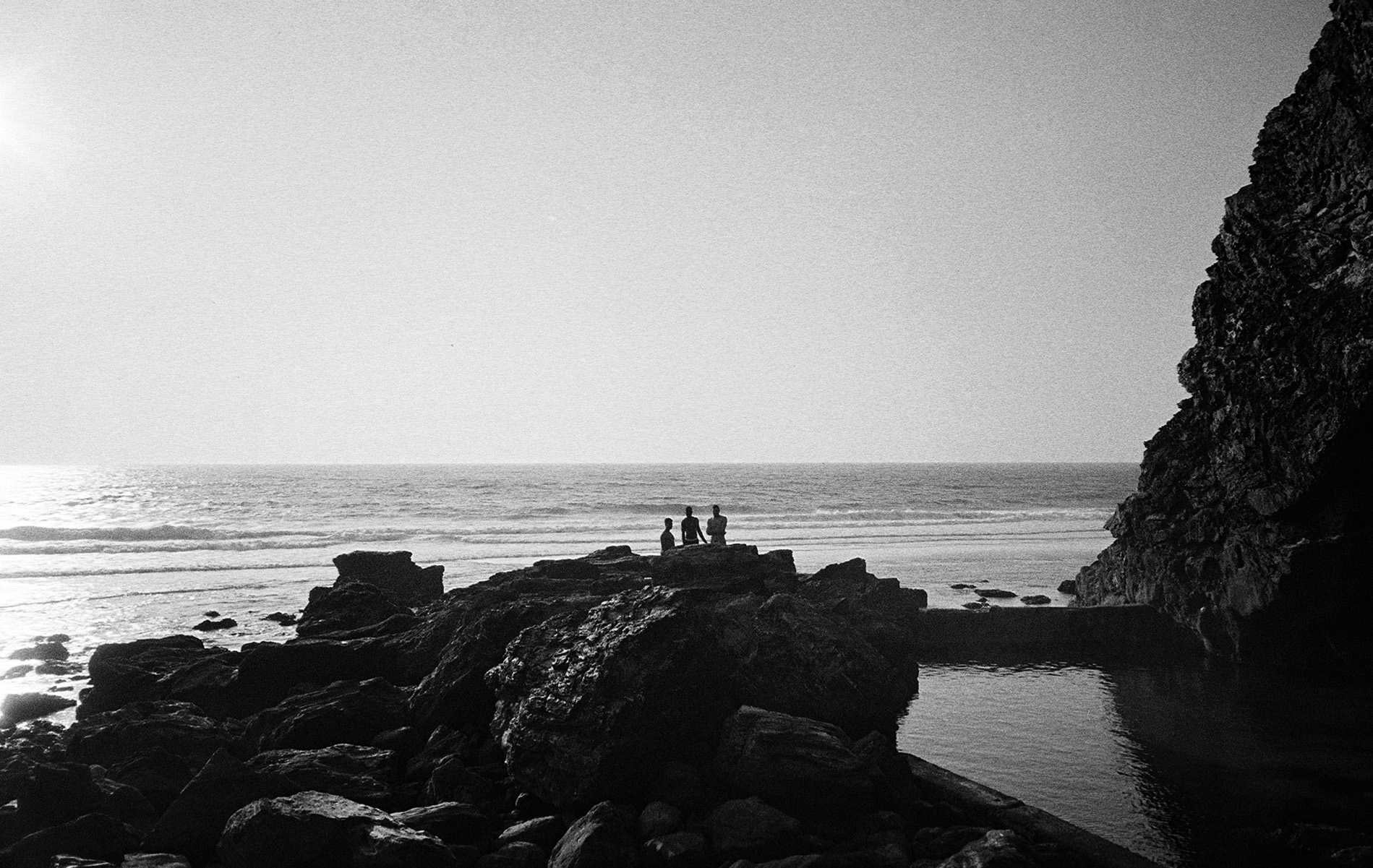 My three friends standing by a rock pool